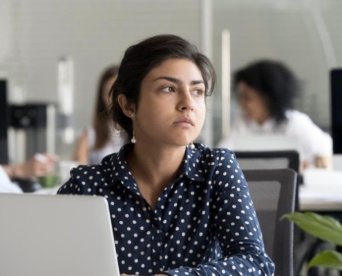 A woman sitting at a table with her laptop.