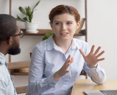 A woman sitting at a table with another person.