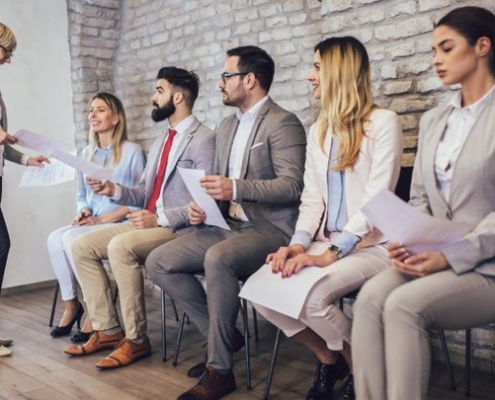 A group of people sitting in chairs holding papers.