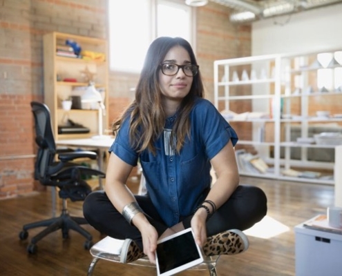 A woman sitting on the ground holding an ipad.