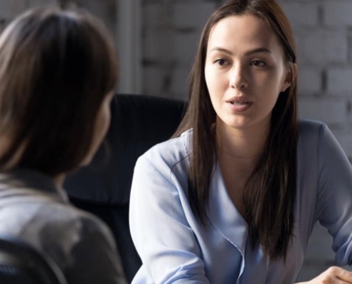 Two women are sitting at a table talking.