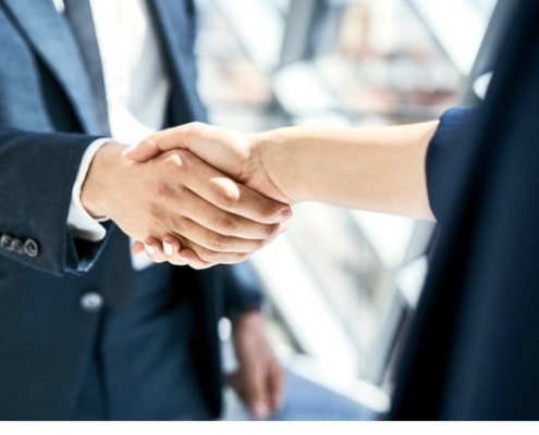 Two people shaking hands in a room.