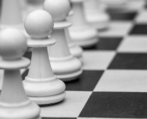 A close up of some white chess pieces on the board