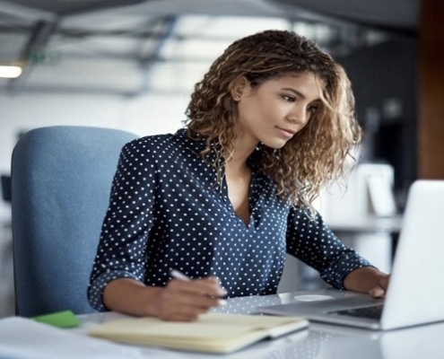 A woman sitting at a desk with a laptop.