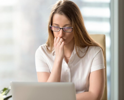 A woman sitting in front of a laptop computer.