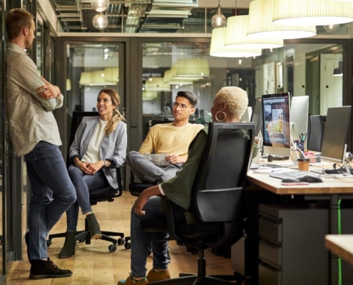 A group of people sitting around a desk.