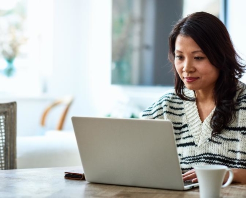 A woman sitting at a table with a laptop.