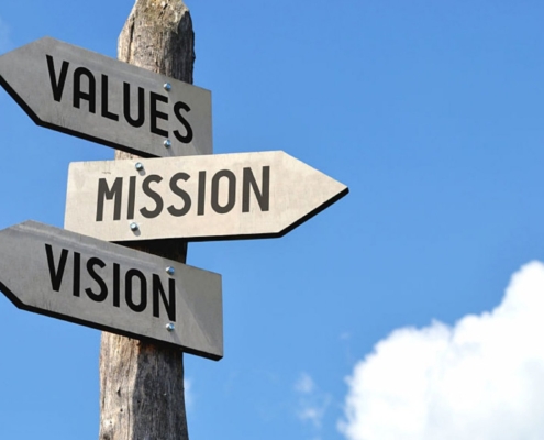 A pole with three signs on it that say values, mission and vision.