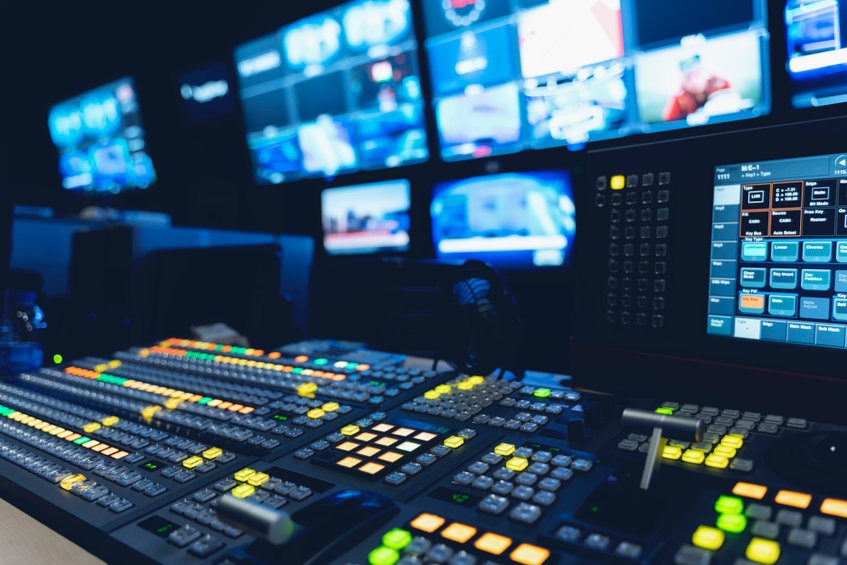 A television control room with multiple monitors and lights.